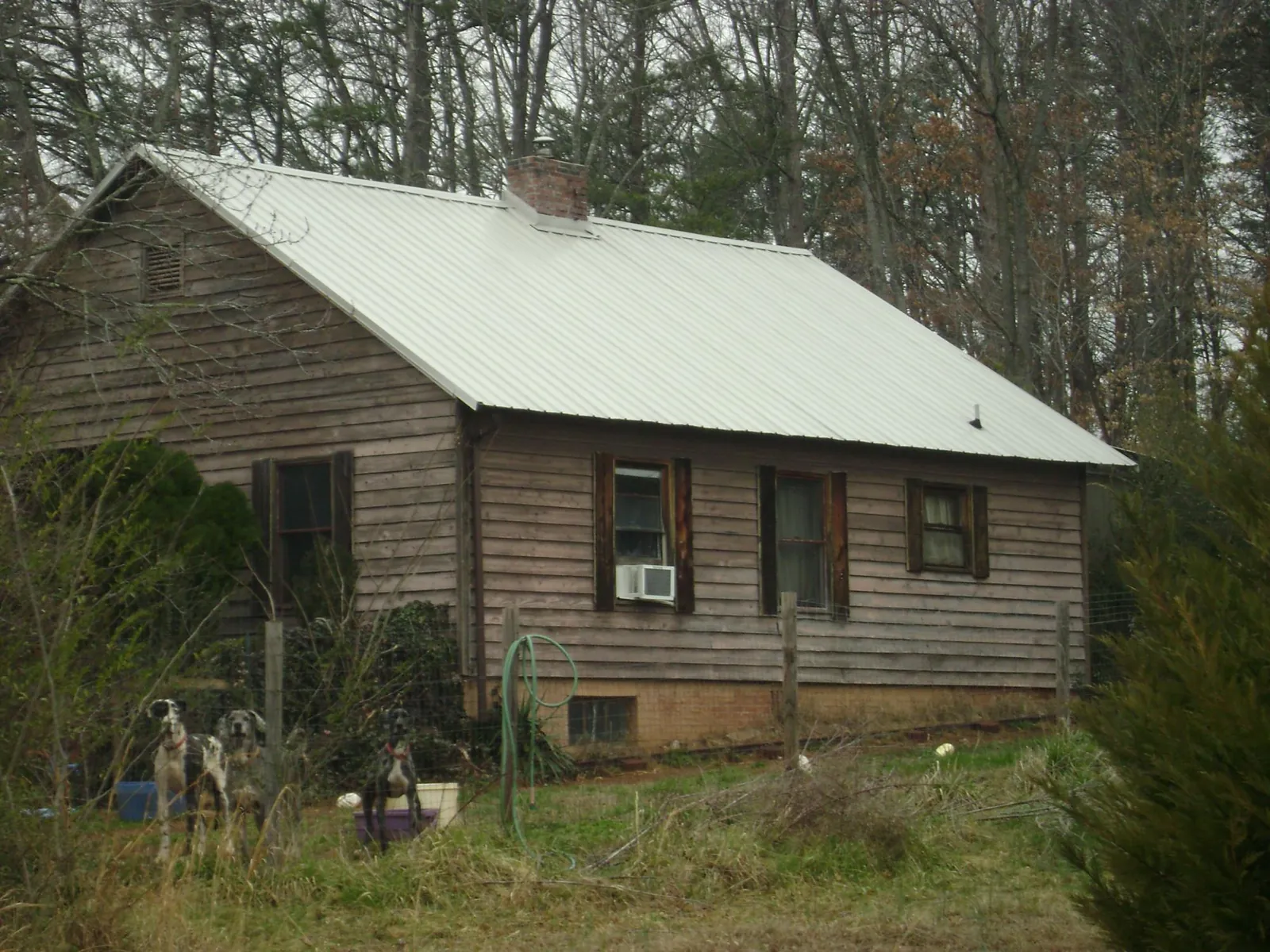 White metal roof on an old wood sided farmhouse, from a Metal Roof Installation job in Dania